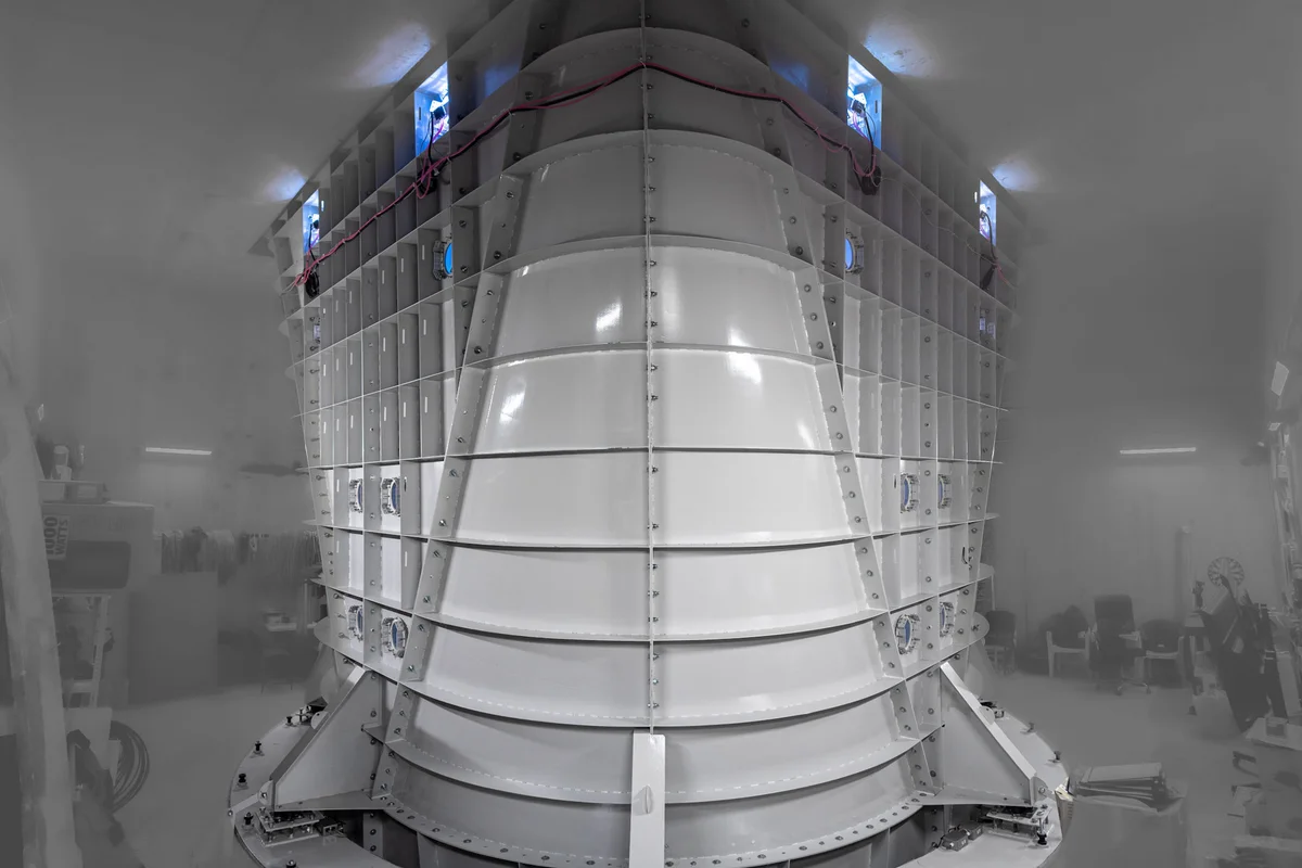 Энэхүү зураг нь Kuzbas Arena байгууламж дахь TunnelTech TT52 Pro салхин хонгилд зориулсан ган диффузорын угсралтын суурилуулалтыг харуулж байна. Энэхүү тэлэгч сувгийн бүрэлдэхүүн хэсэг нь агаарын урсгалыг удаашруулж, рециркуляцтай гогцоон доторх даралтыг сэргээхийн тулд нисэлтийн камерын яг дээд талд байрладаг. Бүтэц нь гадна талын бүтцийн хавирга, боолттой фланцын холболт бүхий сегментчилсэн цагаан ган хавтангуудтай бөгөөд 5.2 метрийн диаметртэй босоо агаарын урсгалын хэлхээний дээд шилжилтийн хэсгийг бүрдүүлдэг.