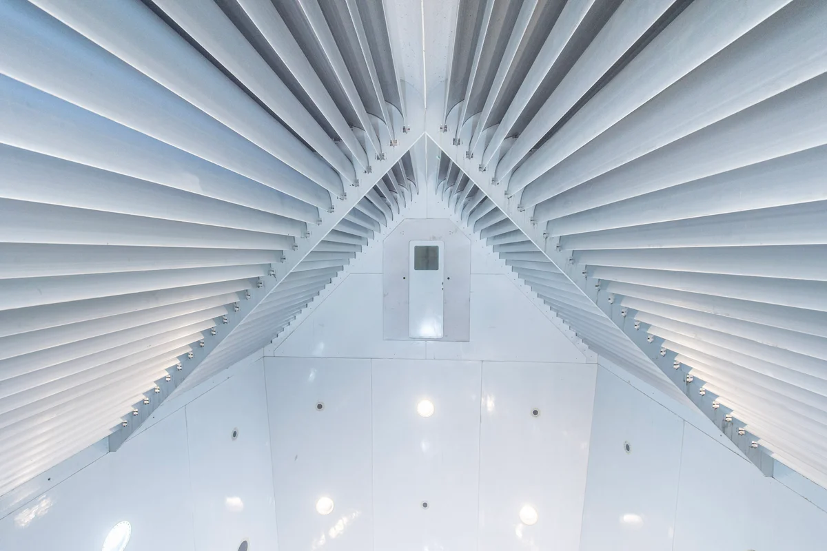 Aluminium keerschoepen zijn gepositioneerd boven de vliegruimte bij FlyStation Japan. De schoepen vormen een V-vormige structuur die is ontworpen om de luchtstroom te splitsen in twee stromen die naar de linker en rechter retourkanalen worden geleid. De deur in het midden van de constructie is de ingang naar de basejump-kamer, waardoor sprongen in de vliegzone mogelijk zijn vanaf een hoogte van bijna 20 meter.